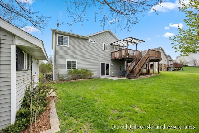 back of property with a lawn, stairway, a deck, and a patio