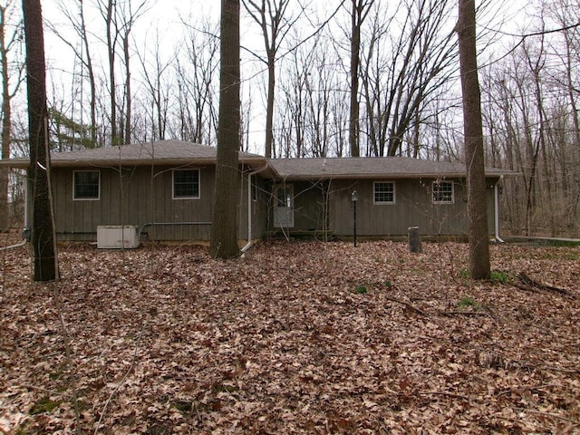 rear view of property featuring roof with shingles