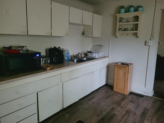 kitchen with black microwave, open shelves, a sink, dark wood-style floors, and ornamental molding