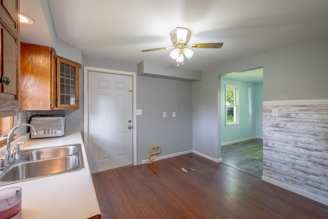 kitchen featuring a sink, brown cabinets, baseboards, and light countertops