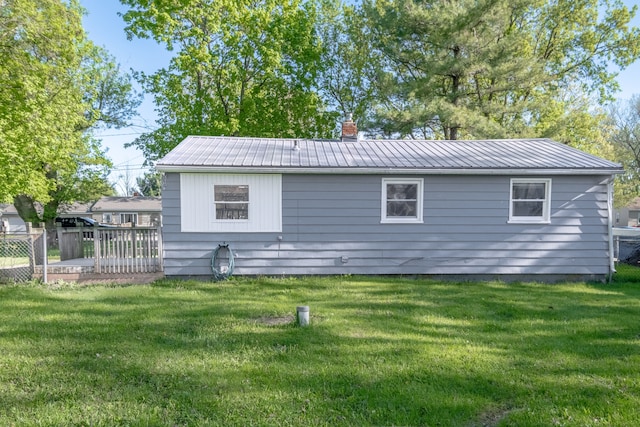 back of house with metal roof and a chimney
