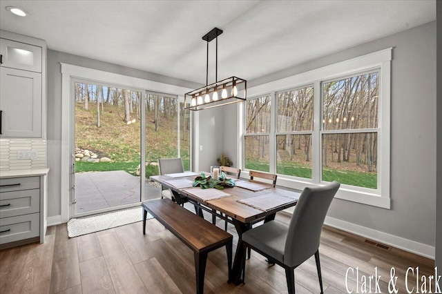dining area with baseboards, recessed lighting, wood finished floors, and visible vents