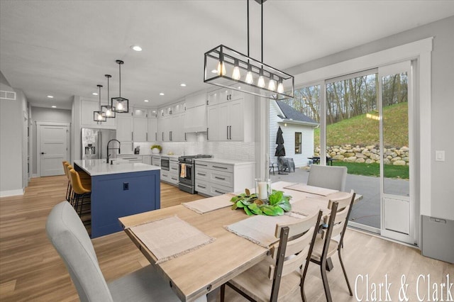 dining space featuring light wood-type flooring, recessed lighting, a chandelier, and visible vents