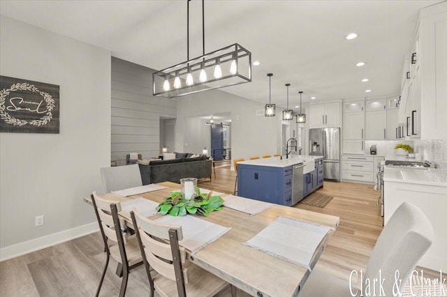 dining space with baseboards, recessed lighting, and light wood finished floors