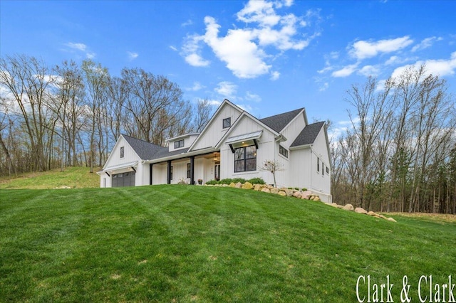 modern farmhouse style home with board and batten siding, an attached garage, a porch, and a front lawn