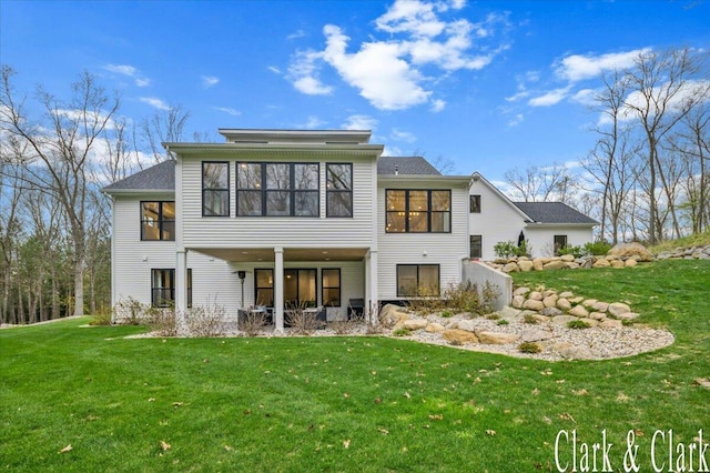 back of property featuring a lawn and a sunroom