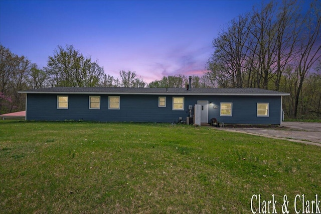 ranch-style house with central AC unit and a front lawn