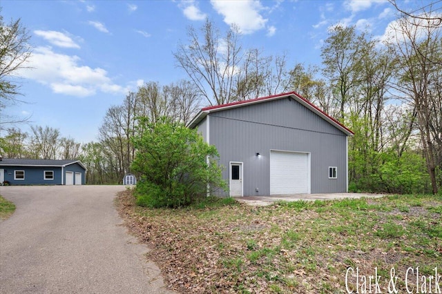 view of property exterior featuring a garage and an outdoor structure