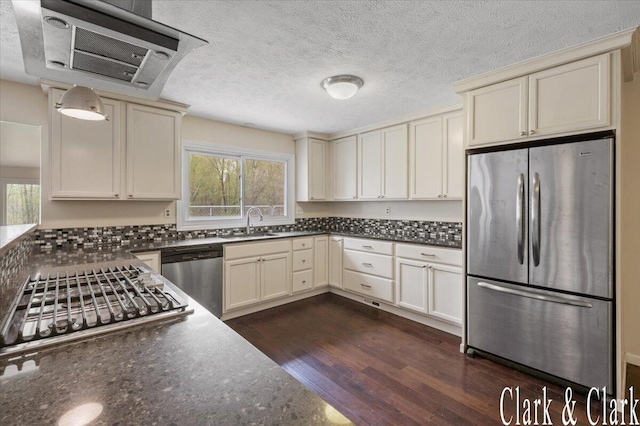 kitchen with stainless steel appliances, dark wood finished floors, plenty of natural light, and cream cabinetry