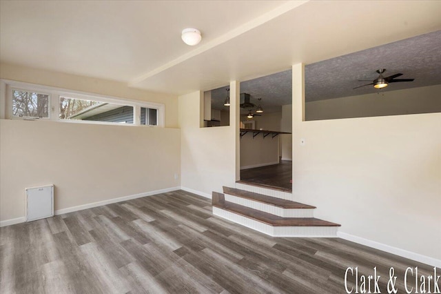 below grade area with stairway, baseboards, and wood finished floors