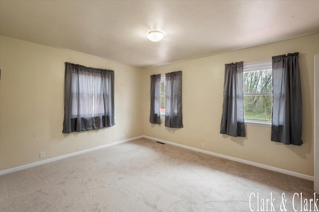 unfurnished room featuring baseboards, carpet flooring, and visible vents