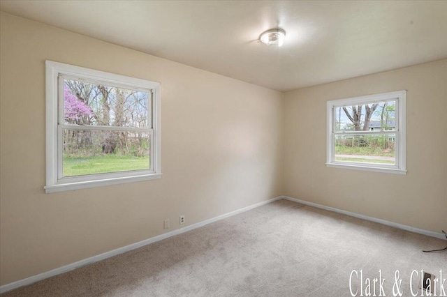 carpeted empty room with baseboards