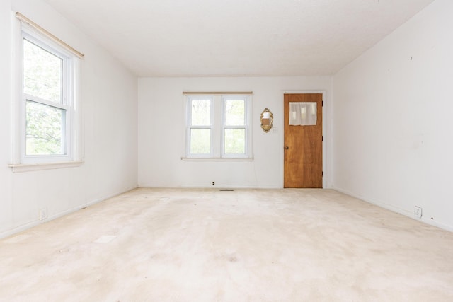 carpeted empty room featuring baseboards
