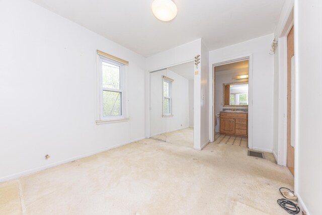 unfurnished bedroom featuring visible vents, carpet flooring, a closet, and multiple windows