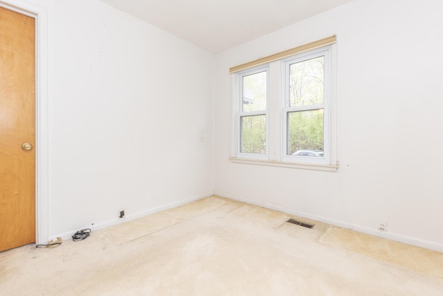 spare room with baseboards, visible vents, and carpet