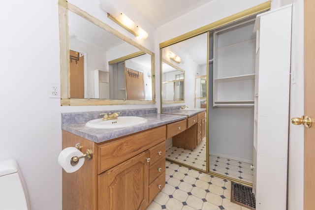 bathroom with toilet, tile patterned floors, vanity, and visible vents