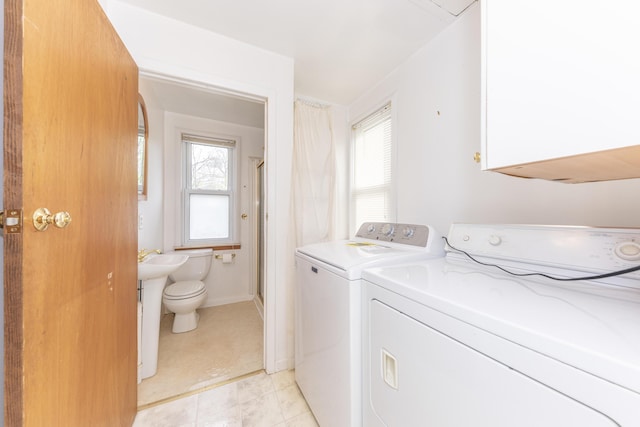 laundry area featuring plenty of natural light, laundry area, baseboards, and washing machine and dryer