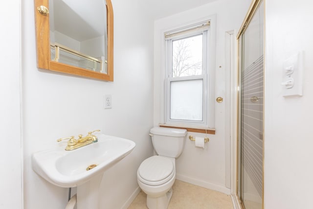 full bathroom featuring baseboards, a sink, a stall shower, and toilet