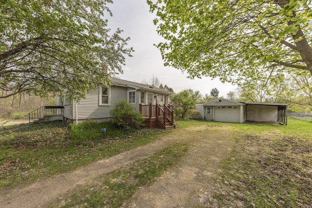 view of yard featuring driveway, an outdoor structure, and a detached garage
