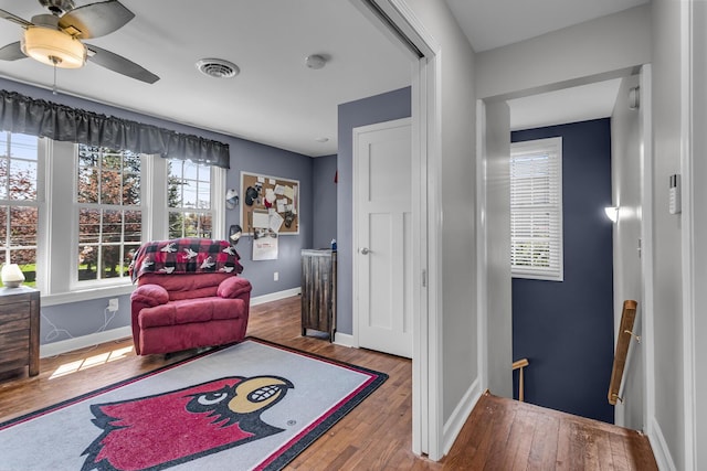 37 N Monroe St, Coldwater, MI 49036 - living area featuring baseboards, wood-type flooring, a ceiling fan, and an upstairs landing