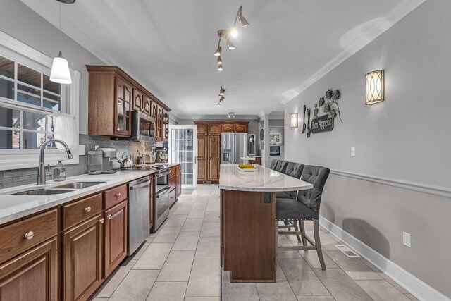 37 N Monroe St, Coldwater, MI 49036 - kitchen with glass insert cabinets, a breakfast bar area, a sink, backsplash, and stainless steel appliances