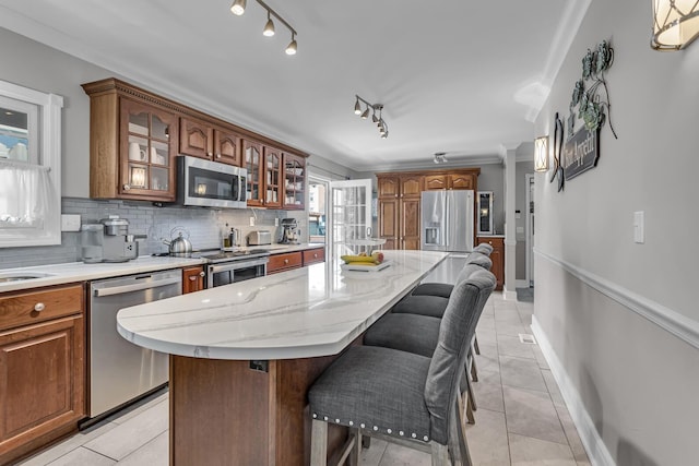 37 N Monroe St, Coldwater, MI 49036 - kitchen featuring tasteful backsplash, light tile patterned floors, glass insert cabinets, a breakfast bar, and stainless steel appliances