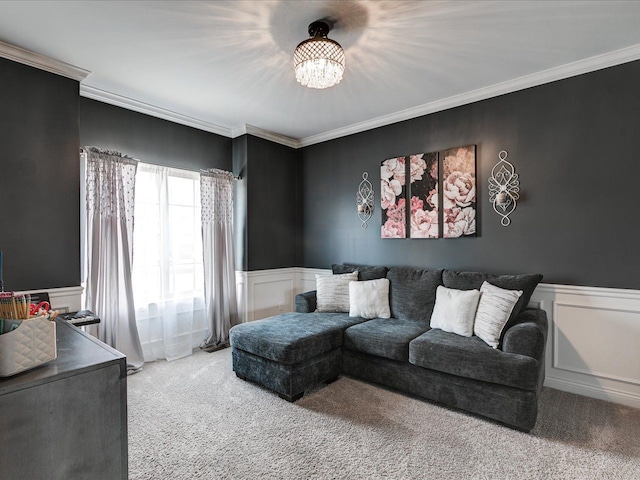 living room featuring carpet, a wainscoted wall, ornamental molding, a decorative wall, and a chandelier