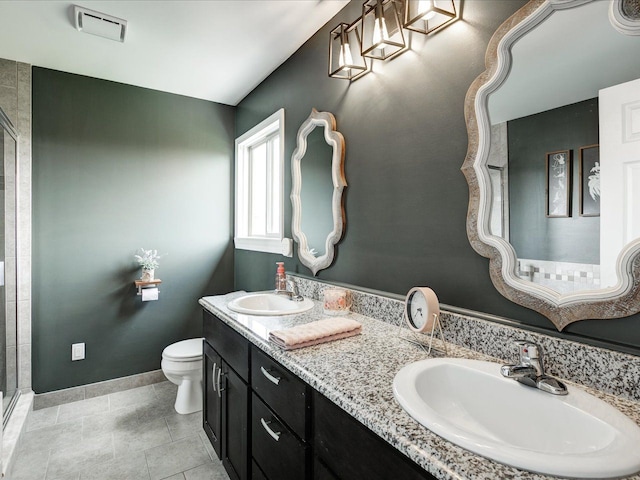 full bathroom featuring a shower stall, toilet, baseboards, double vanity, and tile patterned floors