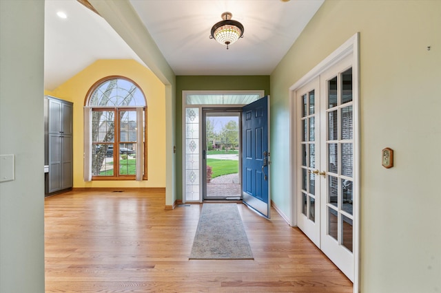 entryway with a healthy amount of sunlight, baseboards, light wood-type flooring, and french doors