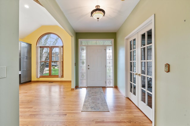 foyer with light wood-type flooring, baseboards, and french doors