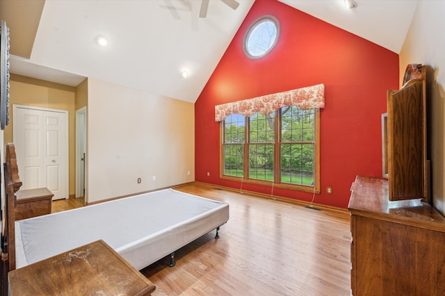 bedroom with ceiling fan, high vaulted ceiling, visible vents, and wood finished floors