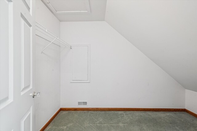 walk in closet with carpet, visible vents, and lofted ceiling