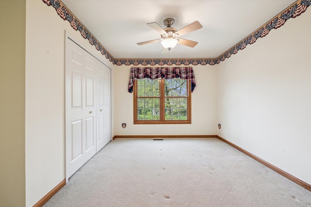unfurnished bedroom featuring baseboards, a closet, a ceiling fan, and carpet floors