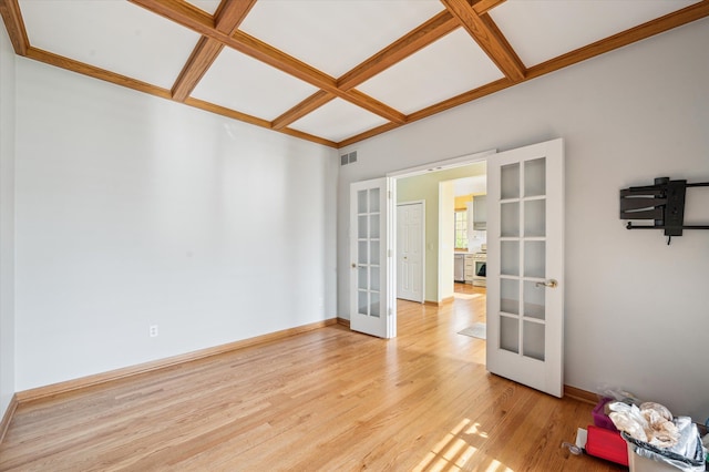 empty room with french doors, visible vents, light wood-style flooring, coffered ceiling, and baseboards