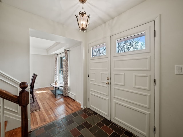 entrance foyer featuring an inviting chandelier, dark wood-type flooring, and baseboards