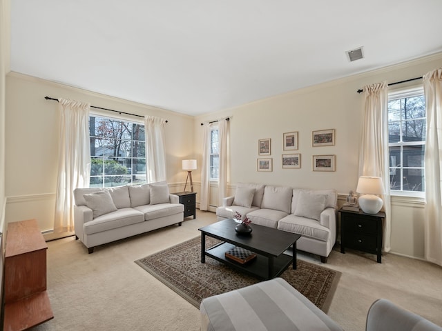living area featuring light carpet, a healthy amount of sunlight, and visible vents