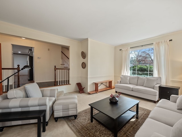 carpeted living area with stairs and crown molding