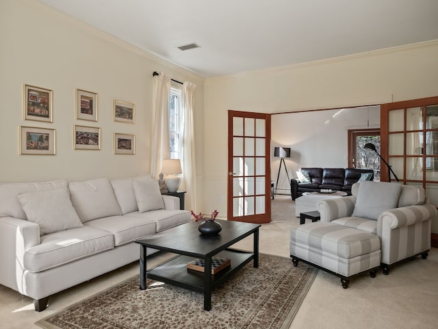 carpeted living room with plenty of natural light, visible vents, and ornamental molding