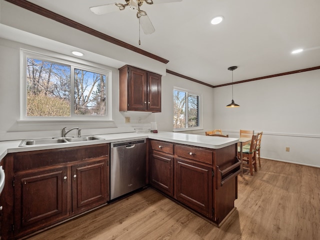 kitchen with a peninsula, a sink, stainless steel dishwasher, and light wood-style floors