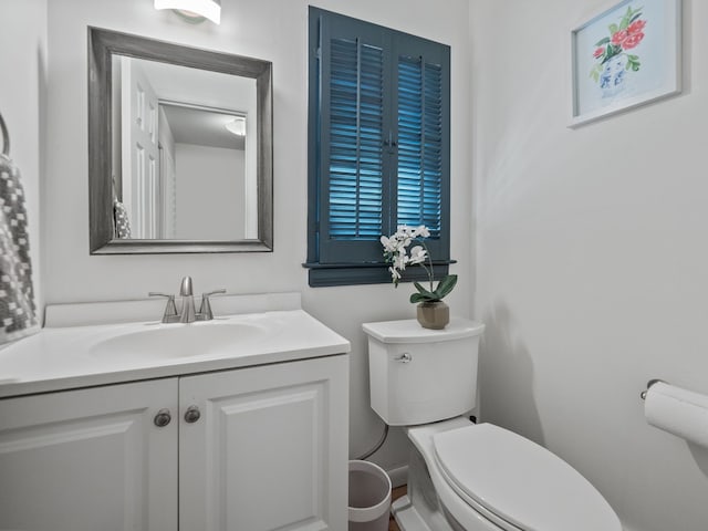 half bath featuring toilet and vanity