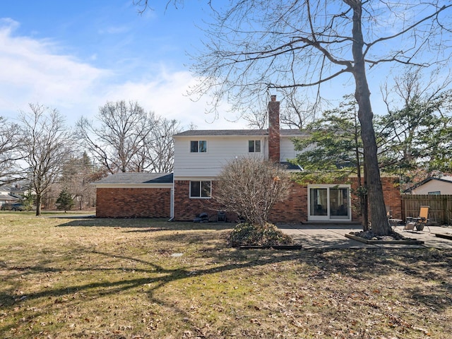 back of house featuring a patio, a yard, a chimney, fence, and brick siding
