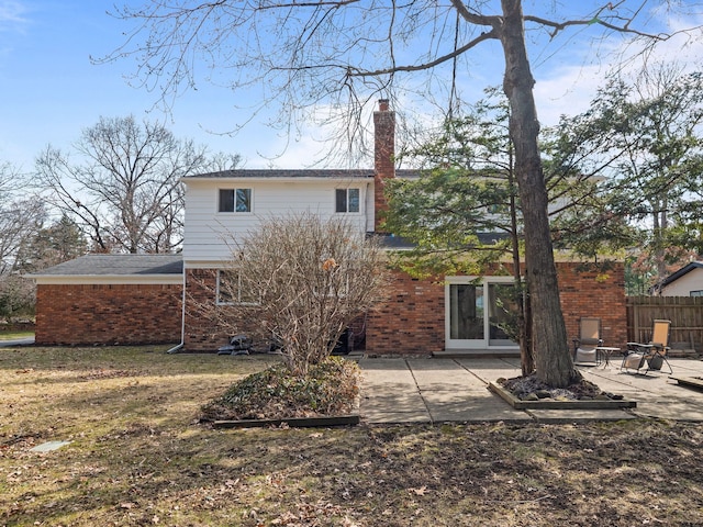 back of house with fence, a patio area, a chimney, and brick siding