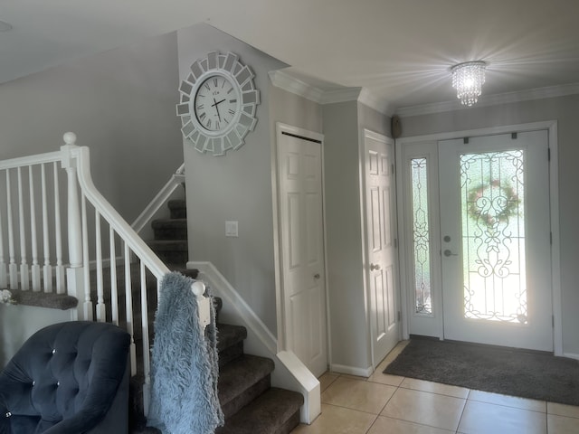 foyer featuring light tile patterned floors, stairway, crown molding, and baseboards