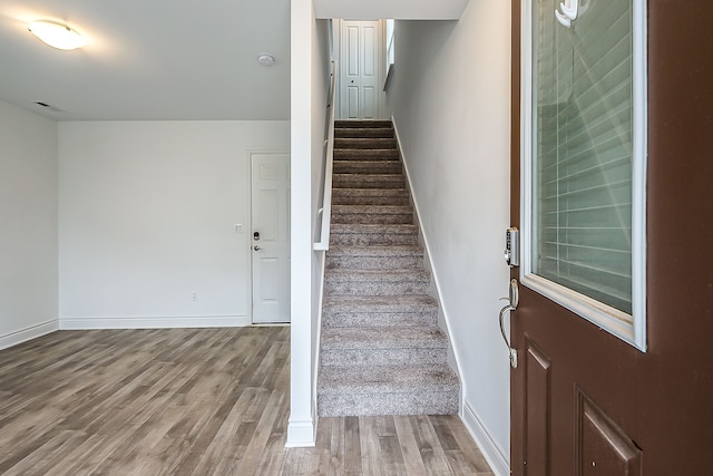587 Anne Ave, Brighton, MI 48116 - staircase with baseboards, visible vents, and wood finished floors