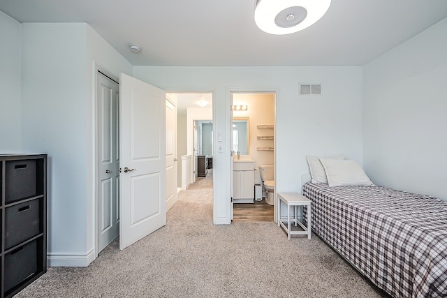 587 Anne Ave, Brighton, MI 48116 - carpeted bedroom with a sink, a closet, ensuite bathroom, visible vents, and baseboards