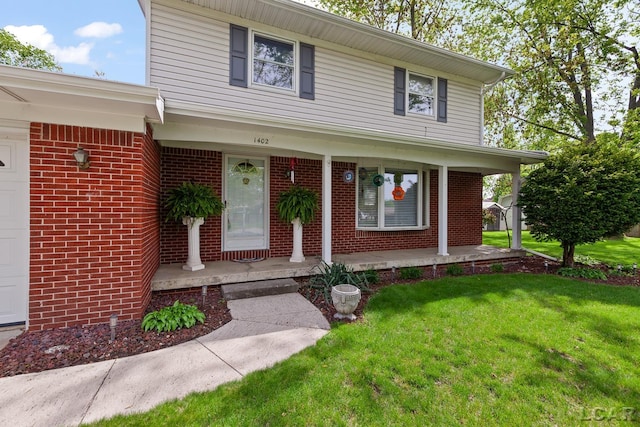 1402 Westhaven Blvd, Tecumseh, MI 49286 - view of front of home featuring covered porch, a front lawn, and brick siding