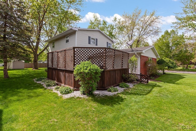 1402 Westhaven Blvd, Tecumseh, MI 49286 - view of property exterior featuring a lawn, a wooden deck, an outdoor structure, and a storage shed