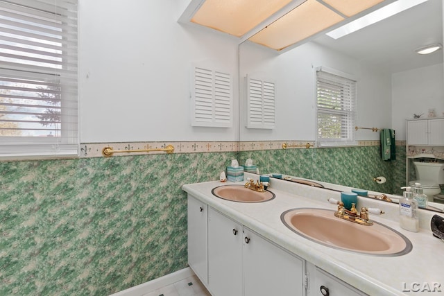 1402 Westhaven Blvd, Tecumseh, MI 49286 - full bathroom featuring a wainscoted wall, double vanity, and toilet