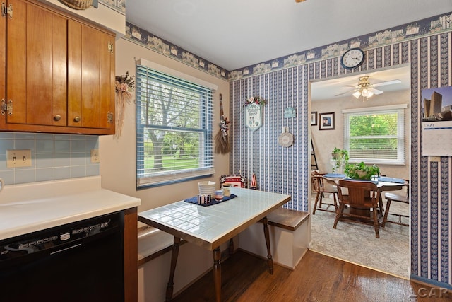 1402 Westhaven Blvd, Tecumseh, MI 49286 - dining area with dark wood-style flooring, ceiling fan, and wallpapered walls