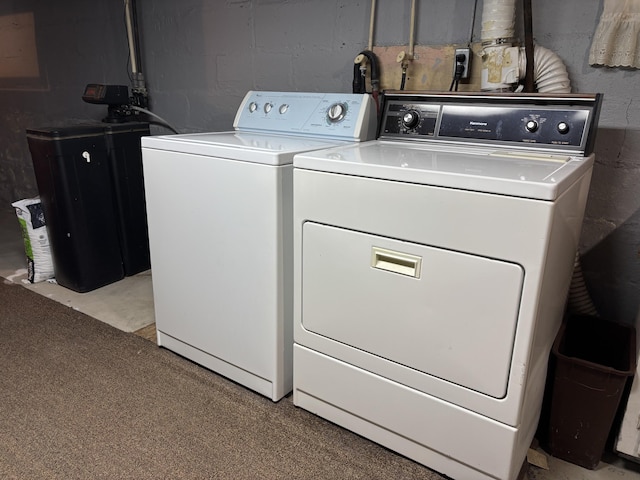 laundry area with separate washer and dryer, laundry area, and concrete block wall